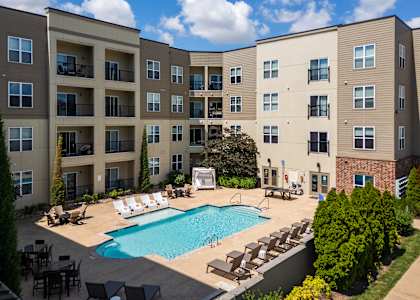 A large apartment complex with a pool in the courtyard.