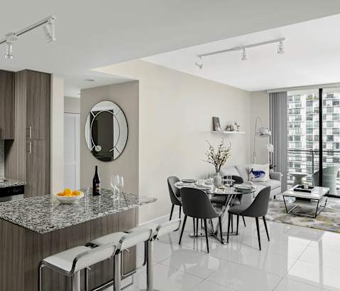 A modern kitchen with a dining table and chairs. at Palma, Doral, FL, 33166
