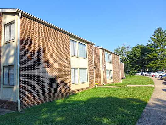 a brick building with a grassy area in front of it