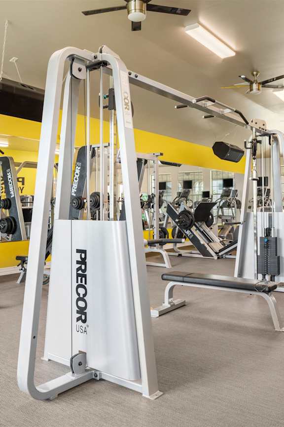 A gym with a PRECOR machine in the foreground.