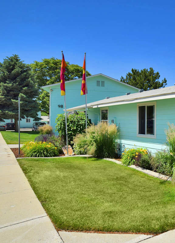 a blue house with two flags in front of it