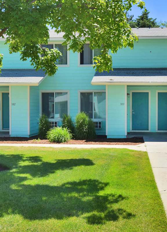 a blue house with a sidewalk in front of it