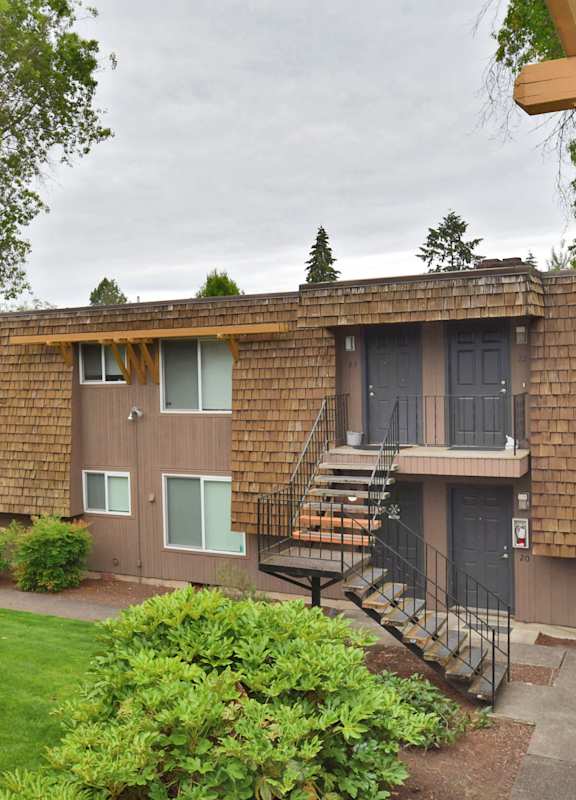 an exterior view of a building with a yard and stairs