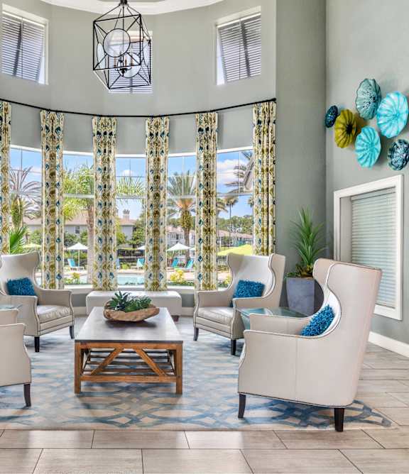 A living room with a large window and a view of a pool.