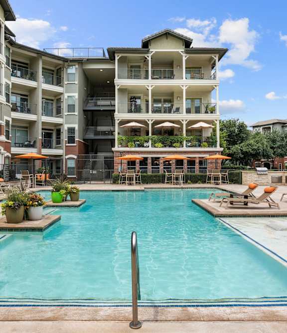 A large swimming pool in front of apartment buildings.