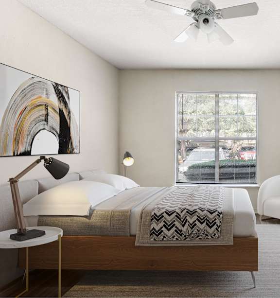 A bedroom with a bed, chair, and a ceiling fan.