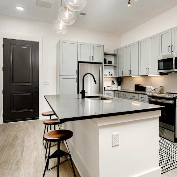 A kitchen with a black countertop and white cabinets. at Vintage Edge Nashville Apartments, Tennessee, 37211