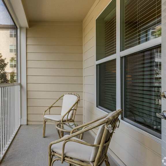 A balcony with a chair and a railing.
