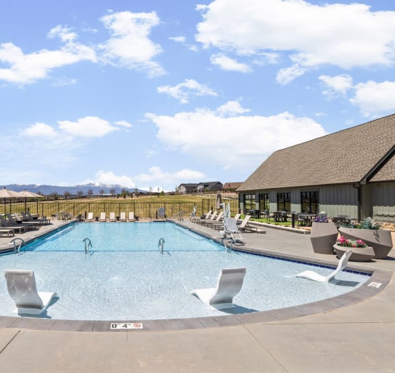 an aerial view of a swimming pool with lounge chairs and a building  at Upland Flats, Colorado Springs, CO