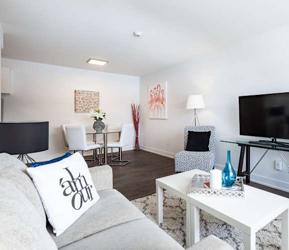A living room with a grey couch and a white coffee table.