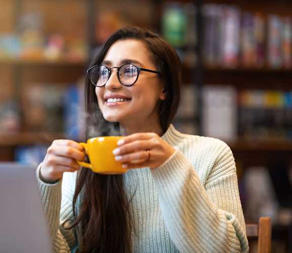 a woman holding a cup of coffee and smiling at Overland Gardens, Maryland