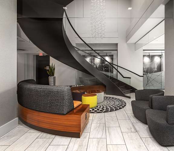 a lobby with chairs and a table and a spiral staircaseat Clayton On The Park, Clayton, MO
