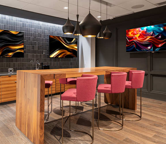 a kitchen with a bar and chairs and paintings on the wallat Clayton On The Park, Clayton, MO