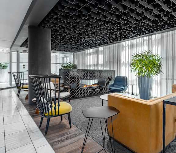 a lobby with a fireplace and a table with chairsat Clayton On The Park, Clayton, MO