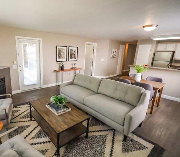 A living room with a grey couch, a coffee table, and a fireplace.