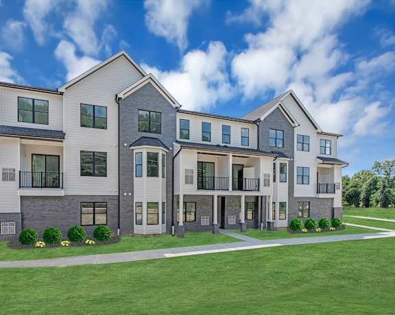 A modern two-story residential building with a well-manicured lawn in front. at The Franklin Marlboro Apartments, Marlboro, NJ 07746