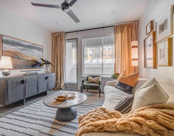 a living room with a couch and a ceiling fan