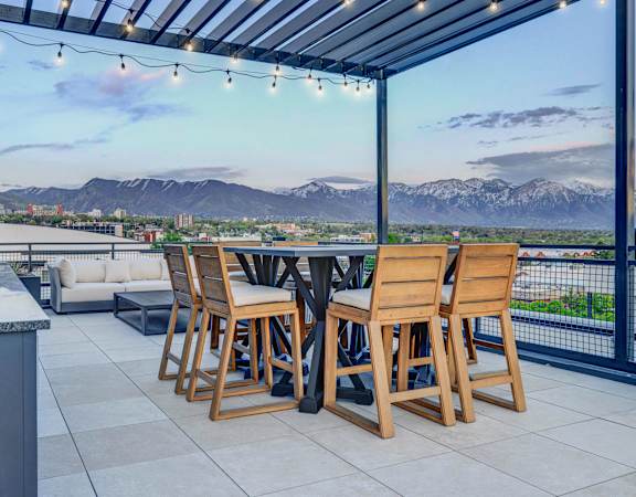 a patio with a table and chairs and a view of the mountains