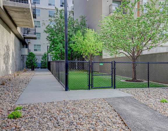 a fenced in tennis court with trees and a chain link fence