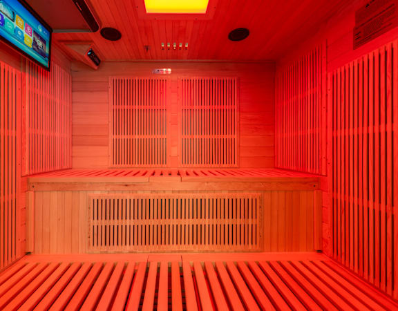 A room with wooden benches and a television mounted on the wall at Clayton on the Park Apartments, Clayton, Missouri