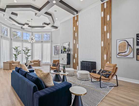 A living room with a blue couch and a chandelier.