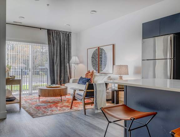 Living space with view of kitchen at The Opal luxury apartments for rent in West Valley City, UT