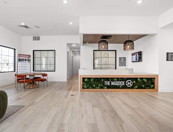 A reception area with a green wall and a sign that says "The Maddox".