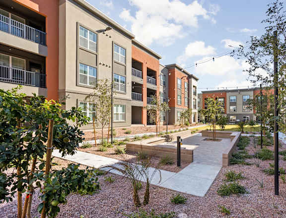 A modern apartment complex with a courtyard and trees.