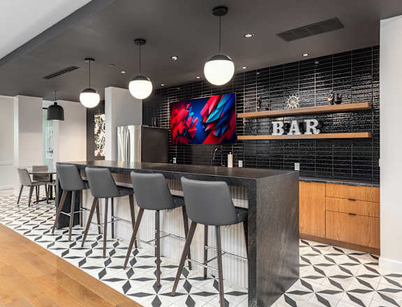 a bar with black and white tiles and a bar table with chairs at 2200 LaSalle Apartments, Missouri, 63104