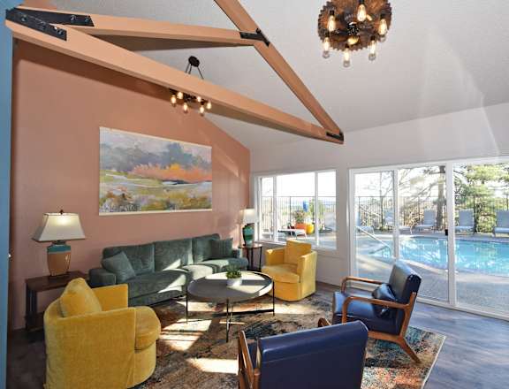A living room with a yellow chair and a green couch.