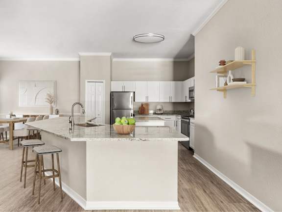A kitchen with a white island and wooden floors.