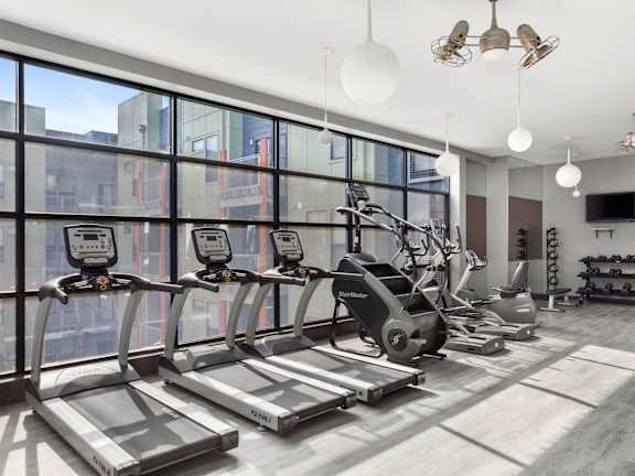 A gym with treadmills, elliptical machines, and other exercise equipment.