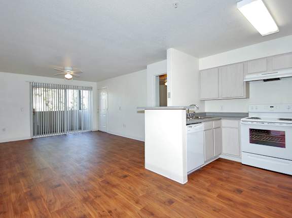 A large empty room with wooden floors and white walls.