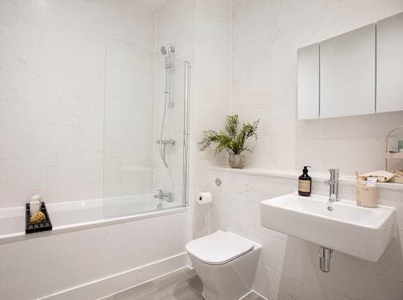 a white bathroom with a sink toilet and bath tub
