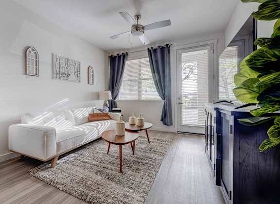 A living room with a white couch and a ceiling fan.
