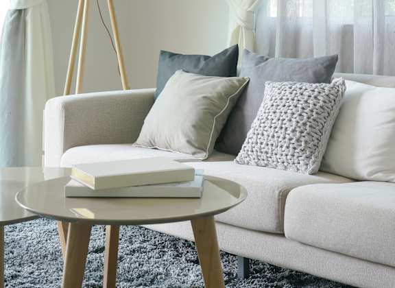 luxury apartment with white couch with grey pillows and a round coffee table