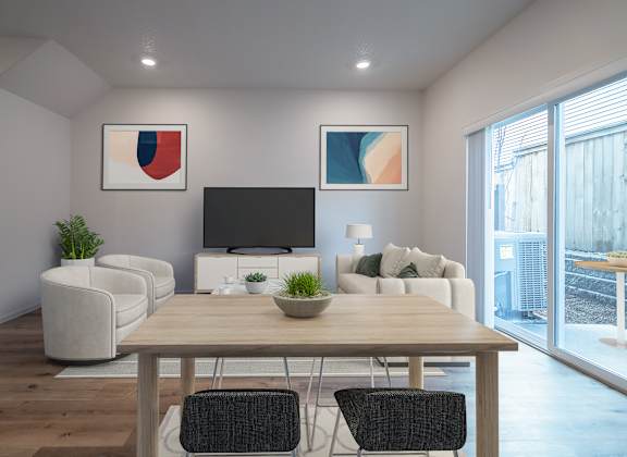 A modern living room with a wooden dining table and chairs.
