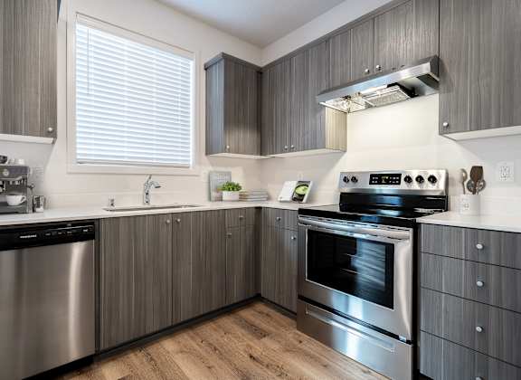 A modern kitchen with stainless steel appliances and wooden cabinets.