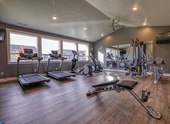 a gym with exercise equipment and windows with a view