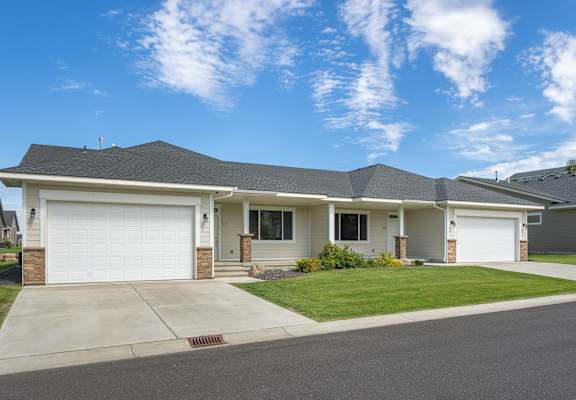 A house with a white garage door and a grey roof.