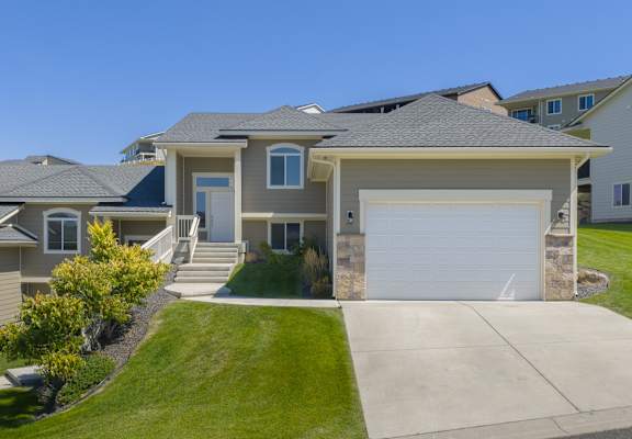 A house with a grey roof and a white garage door.