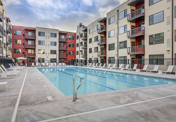 an apartment swimming pool in front of an apartment building