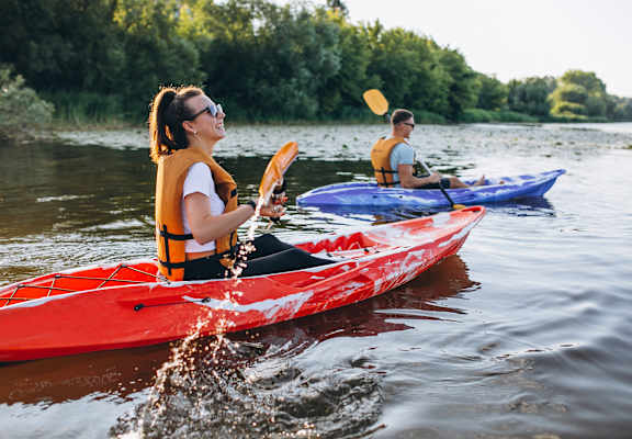Two people kayaking on a river.