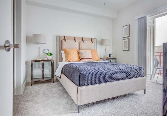 A bedroom with a bed, nightstands, and a chair.