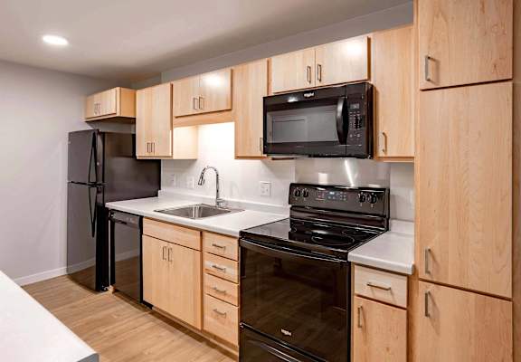 a kitchen with black appliances and wooden cabinets
