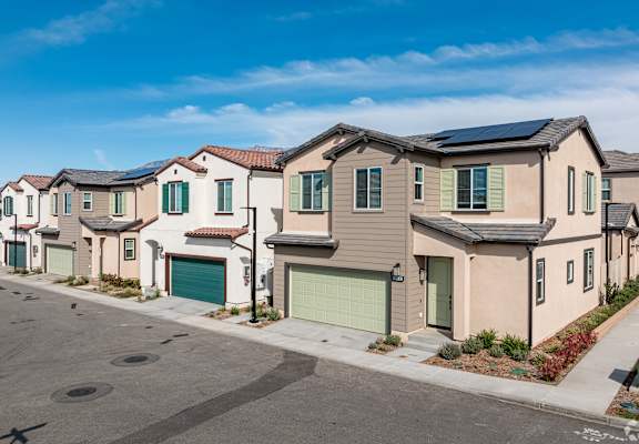 A row of houses with solar panels on the roofs.
