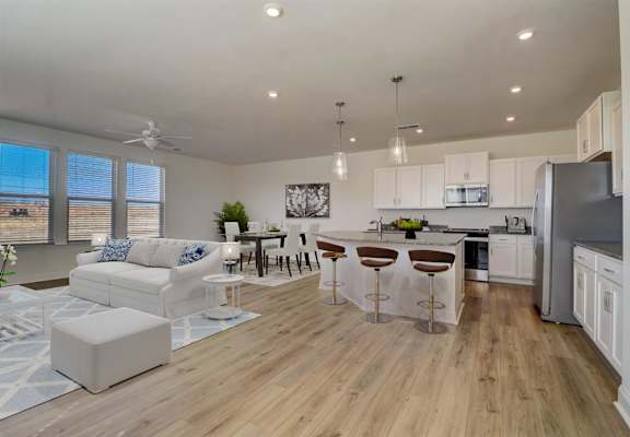 A modern kitchen with white cabinets and a wooden floor.