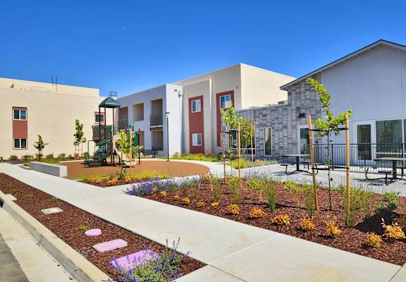 a courtyard in front of a building with benches and plants