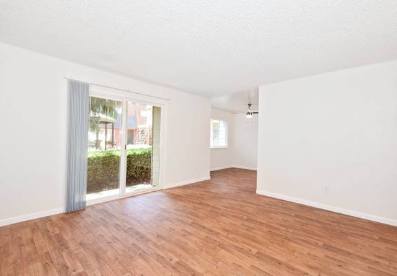 an empty room with white walls and wood floors