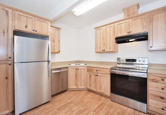 a kitchen with wooden cabinets and stainless steel appliances